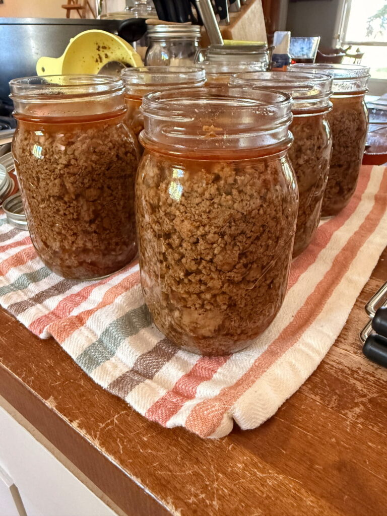 filling taco meat into jars to can